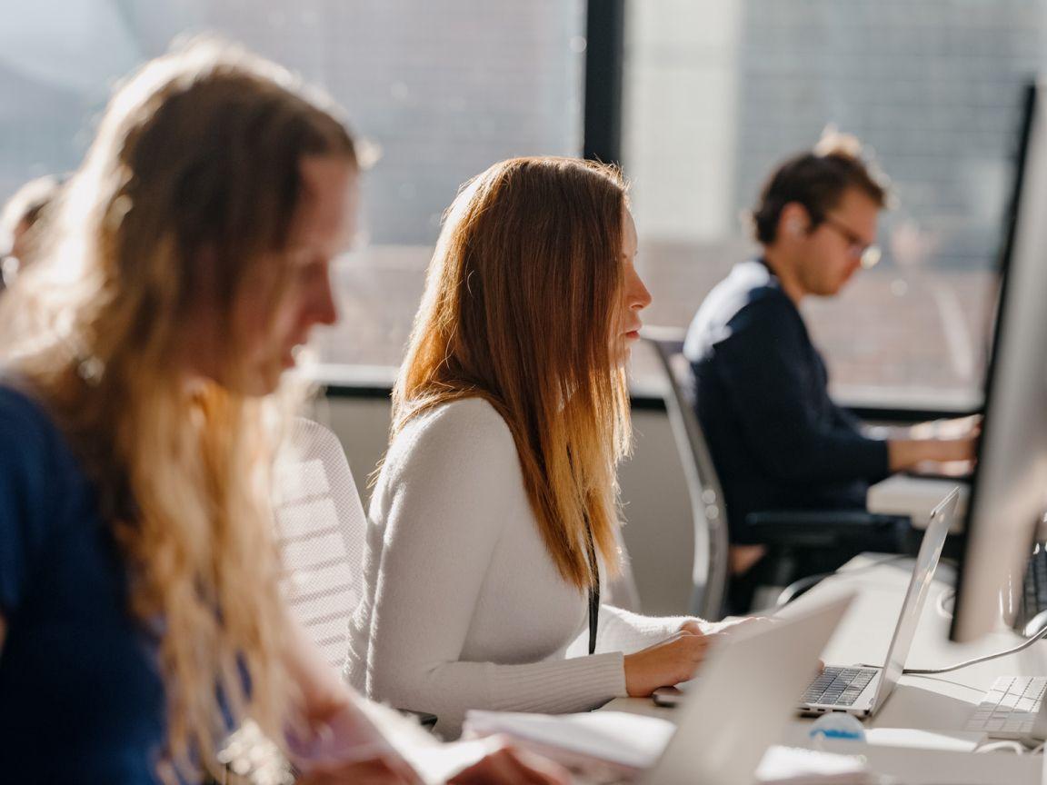 Three people working at computers